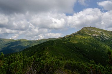 Bulutlu gökyüzü ile dağlık manzaranın güzel manzarası