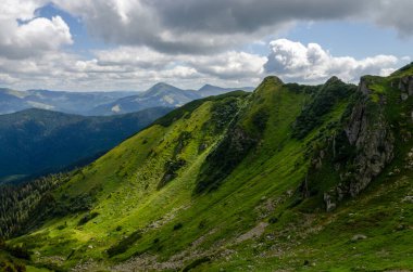 Bulutlu gökyüzü ile dağlık manzaranın güzel manzarası