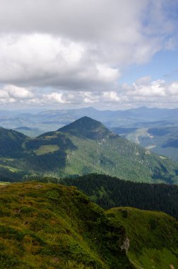 Bulutlu gökyüzü ile dağlık manzaranın güzel manzarası
