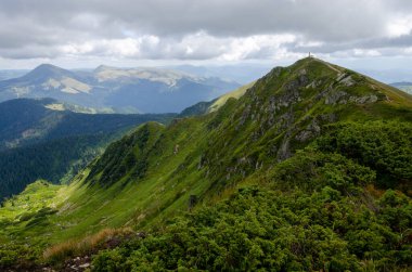 Bulutlu gökyüzü ile dağlık manzaranın güzel manzarası