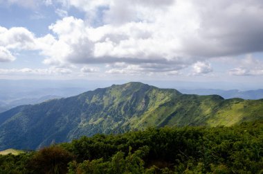 Bulutlu gökyüzü ile dağlık manzaranın güzel manzarası
