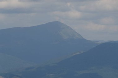 Bulutlu gökyüzü ile dağlık manzaranın güzel manzarası