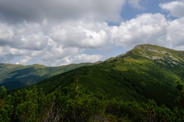 Bulutlu gökyüzü ile dağlık manzaranın güzel manzarası