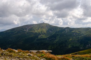 Bulutlu gökyüzü ile dağlık manzaranın güzel manzarası