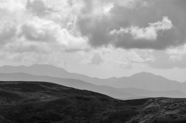bulutlu gökyüzü ile dağlık arazinin siyah ve beyaz görüntüsü
