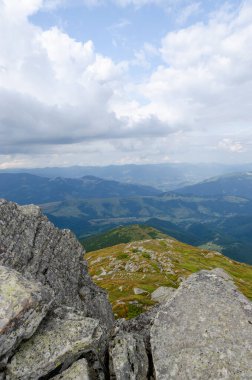 Bulutlu gökyüzü ile dağlık manzaranın güzel manzarası