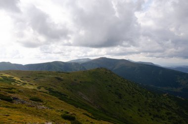 Bulutlu gökyüzü ile dağlık manzaranın güzel manzarası