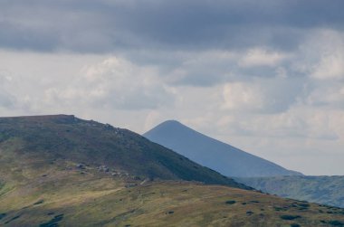 Bulutlu gökyüzü ile dağlık manzaranın güzel manzarası
