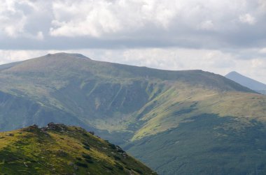 Bulutlu gökyüzü ile dağlık manzaranın güzel manzarası