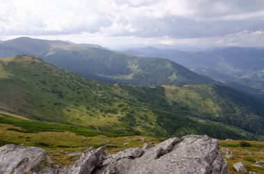 Bulutlu gökyüzü ile dağlık manzaranın güzel manzarası