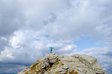 Yürüyüşçü parlak güneş ışığında tepenin üstünde duruyor.