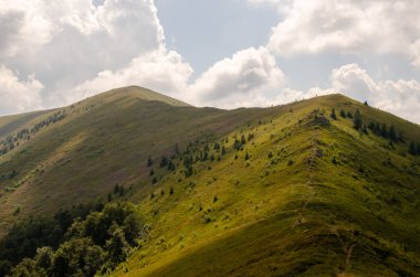 Bulutlu gökyüzü ile dağlık manzaranın güzel manzarası