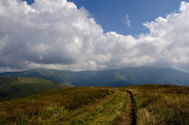 Bulutlu gökyüzü ile dağlık manzaranın güzel manzarası