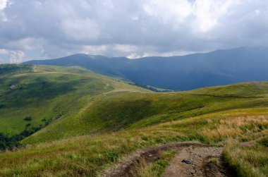 Bulutlu gökyüzü ile dağlık manzaranın güzel manzarası