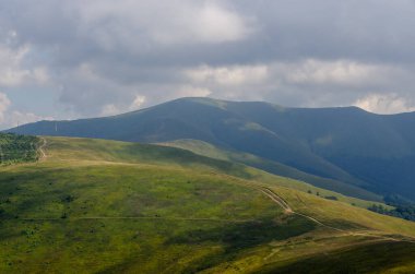 Bulutlu gökyüzü ile dağlık manzaranın güzel manzarası