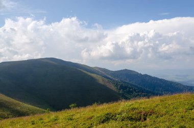 Bulutlu gökyüzü ile dağlık manzaranın güzel manzarası