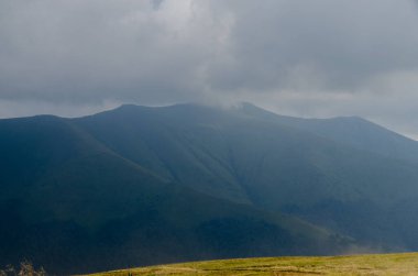 Bulutlu gökyüzü ile dağlık manzaranın güzel manzarası