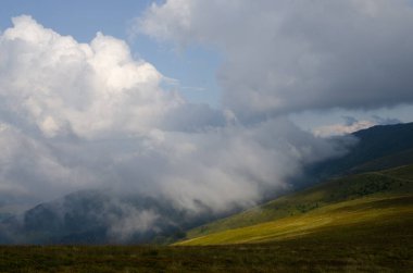 Bulutlu gökyüzü ile dağlık manzaranın güzel manzarası