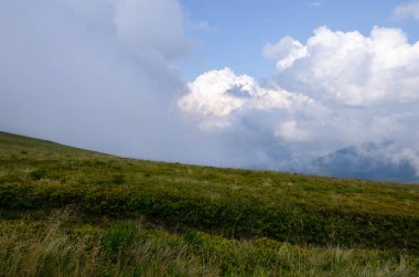 Bulutlu gökyüzü ile dağlık manzaranın güzel manzarası