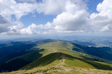 Bulutlu gökyüzü ile dağlık manzaranın güzel manzarası