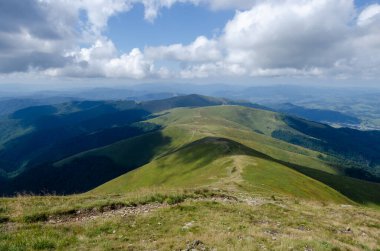 Bulutlu gökyüzü ile dağlık manzaranın güzel manzarası