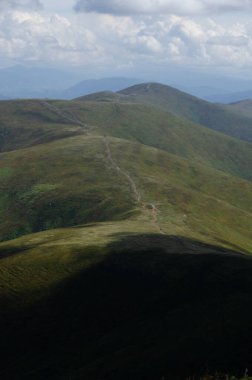 Bulutlu gökyüzü ile dağlık manzaranın güzel manzarası
