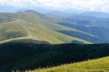 Bulutlu gökyüzü ile dağlık manzaranın güzel manzarası