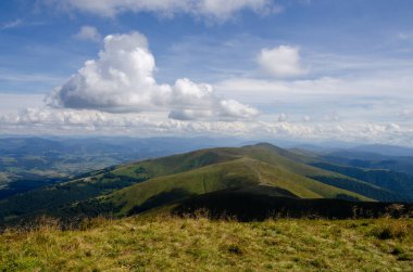 Bulutlu gökyüzü ile dağlık manzaranın güzel manzarası