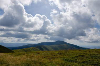 Bulutlu gökyüzü ile dağlık manzaranın güzel manzarası