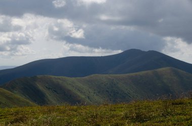 Bulutlu gökyüzü ile dağlık manzaranın güzel manzarası