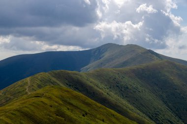 Bulutlu gökyüzü ile dağlık manzaranın güzel manzarası