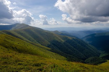 Bulutlu gökyüzü ile dağlık manzaranın güzel manzarası