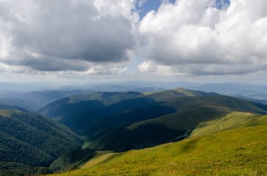 Bulutlu gökyüzü ile dağlık manzaranın güzel manzarası