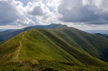 Bulutlu gökyüzü ile dağlık manzaranın güzel manzarası