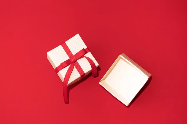 Caja de regalo blanca con cinta roja sobre fondo rojo. Concepto de Día de San Valentín, copiar espacio y maqueta — Foto de Stock
