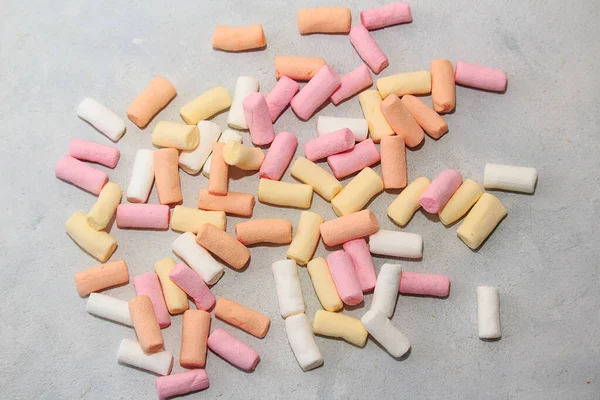 Sötsaker. Konceptet att kontrollera socker och insulin i kroppen. Flerfärgade marshmallows på en grå bakgrund. — Stockfoto