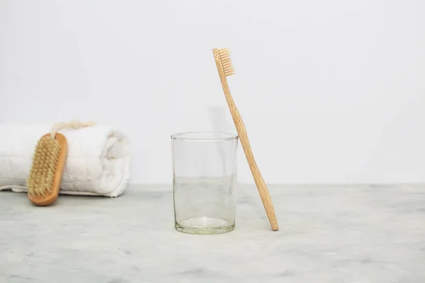 Eco bamboo tooth brushes in a glass and white towe, nail brush in white background. Concept of zero waste and eco-friendly products