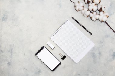 Pamuk dalı ve cep telefonu ile düz kompozisyon, gri arka planda not. Narin beyaz pamuk çiçekleri