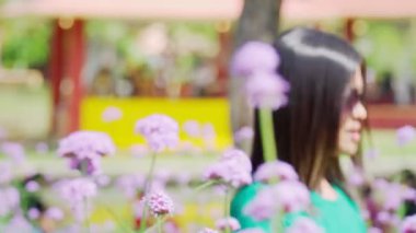 Dönüşüm, bahçede çiçekleri izleyen bir kadının portresi..