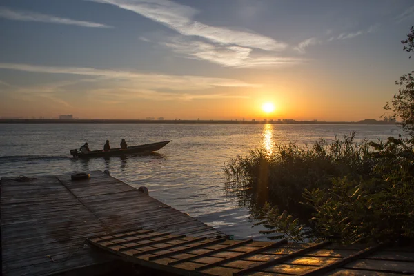 Yükselen güneş ışınlarının içinde yüzen tekne
