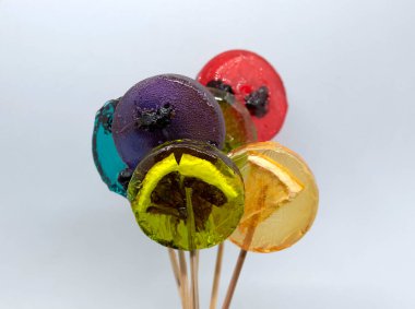 Meyveli lolipopların içinde farklı meyveler ve meyveler var..