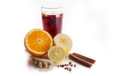 Bir cam baharat, zencefil, limon, tarçın ve meyve beyaz bir arka plan üzerinde mulled şarap