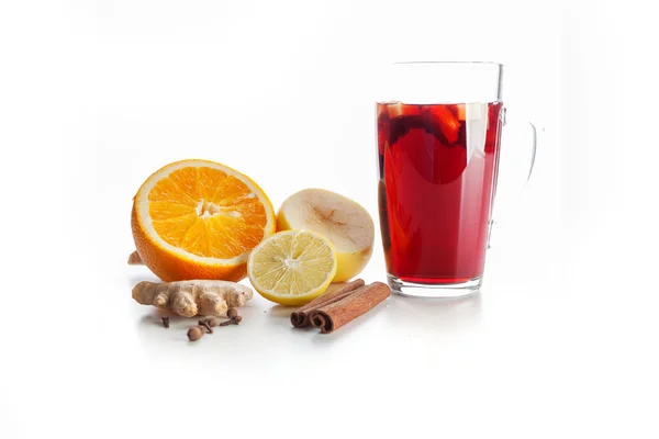 Glühwein in een glas met specerijen, gember, citroen, kaneel en fruit op een witte achtergrond — Stockfoto