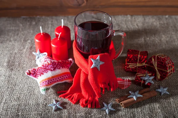 Mulled wine in a glass with spices, ginger, lemon, cinnamon and fruit on a wooden background — Stock Photo, Image