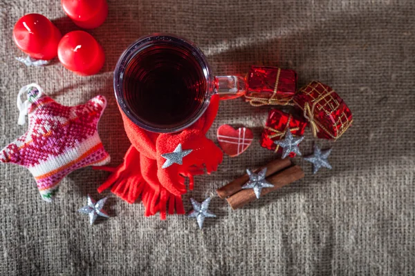 Vino caliente en una copa con especias, jengibre, limón, canela y fruta sobre un fondo de madera —  Fotos de Stock