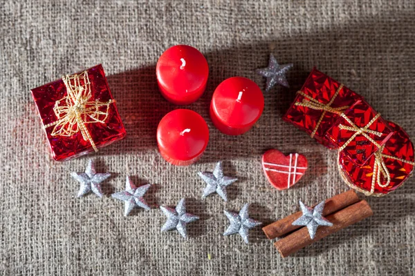 Noel süsleri, mumlar, hediyeler keten zemin üzerine — Stok fotoğraf