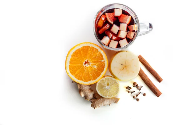 Vin chaud dans un verre avec épices, gingembre, citron, cannelle et fruits sur fond blanc Images De Stock Libres De Droits