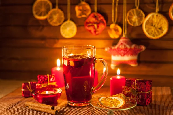 Ποτήρι ζεστό κρασί και διακοσμήσεις Χριστουγέννων, κεριά, δώρα σε λινό φόντο — Φωτογραφία Αρχείου