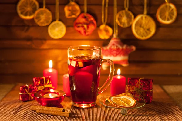 Ποτήρι ζεστό κρασί και διακοσμήσεις Χριστουγέννων, κεριά, δώρα σε λινό φόντο — Φωτογραφία Αρχείου