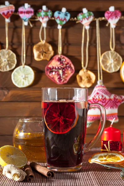 Glass of mulled wine and Christmas decorations, candles, gifts on linen background — Stock Photo, Image